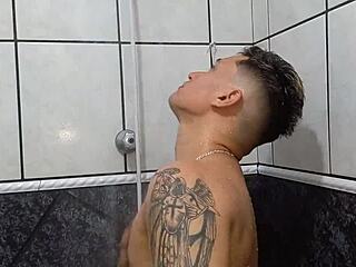 Young tattooed guy masturbates in the shower