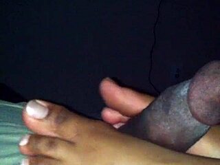 Ebony amateur performs footjob on black guy in erotic movie scene