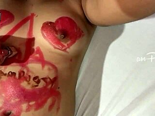 Intriguing close-up of amateur asian girl painting her shaved body with lipstick