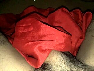 Bisexual shemale's masturbation session in red silk satin