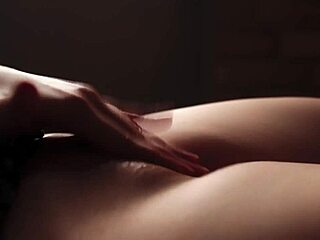 A beautiful young woman pleases herself by touching her breasts and vagina