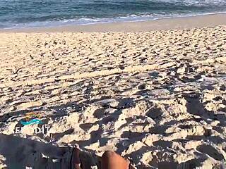 Brazilian amateur masturbates on the beach while bent over, big tits and ass exposed, watched by naughty vendor