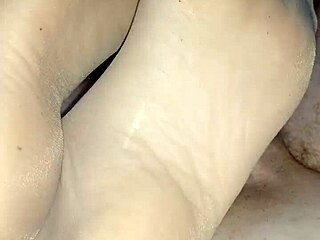 Beautiful girlfriend in sheer nylons gives a sensual footjob