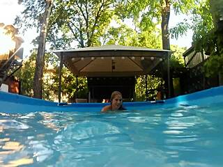 melissa the mermaid swims in the pool with her brown eyes and tattoo