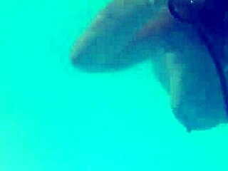 melissa the mermaid swims in the pool with her brown eyes and tattoo