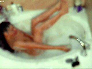 The young boy enjoys the bath, ladling water and washing himself