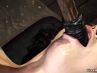 A busty slave in shackles is being toyed with