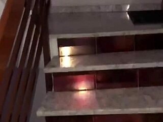 Couple enjoys intimate moments on the stairs, unseen