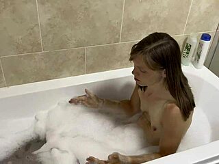 Brunette with blue eyes sings naked in the bath.