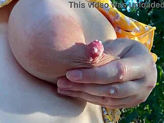 Pregnant wife milks huge lactating boobs outdoors in close up view