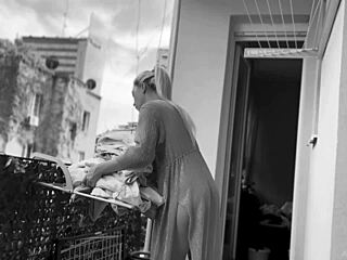 Naked chubby woman casually hangs laundry on balcony while neighbors watch her shaved pussy