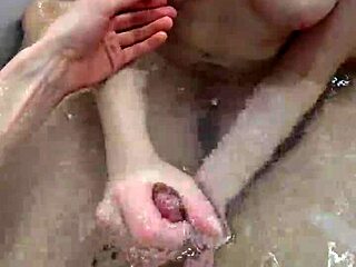 In the bath, she gave a close-up handjob to her boyfriend's big cock. It ended with a hot underwater cumshot explosion.